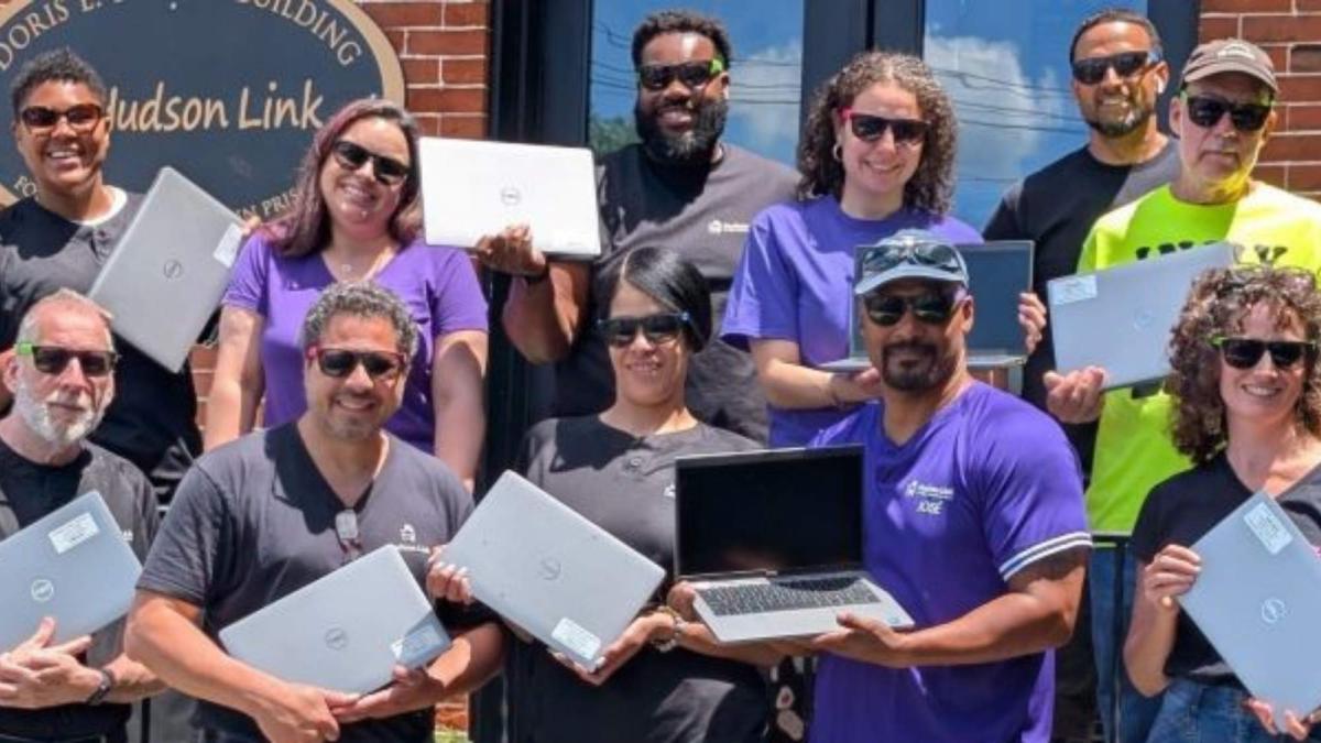 Hudson Link team holding donated laptops during a group photo