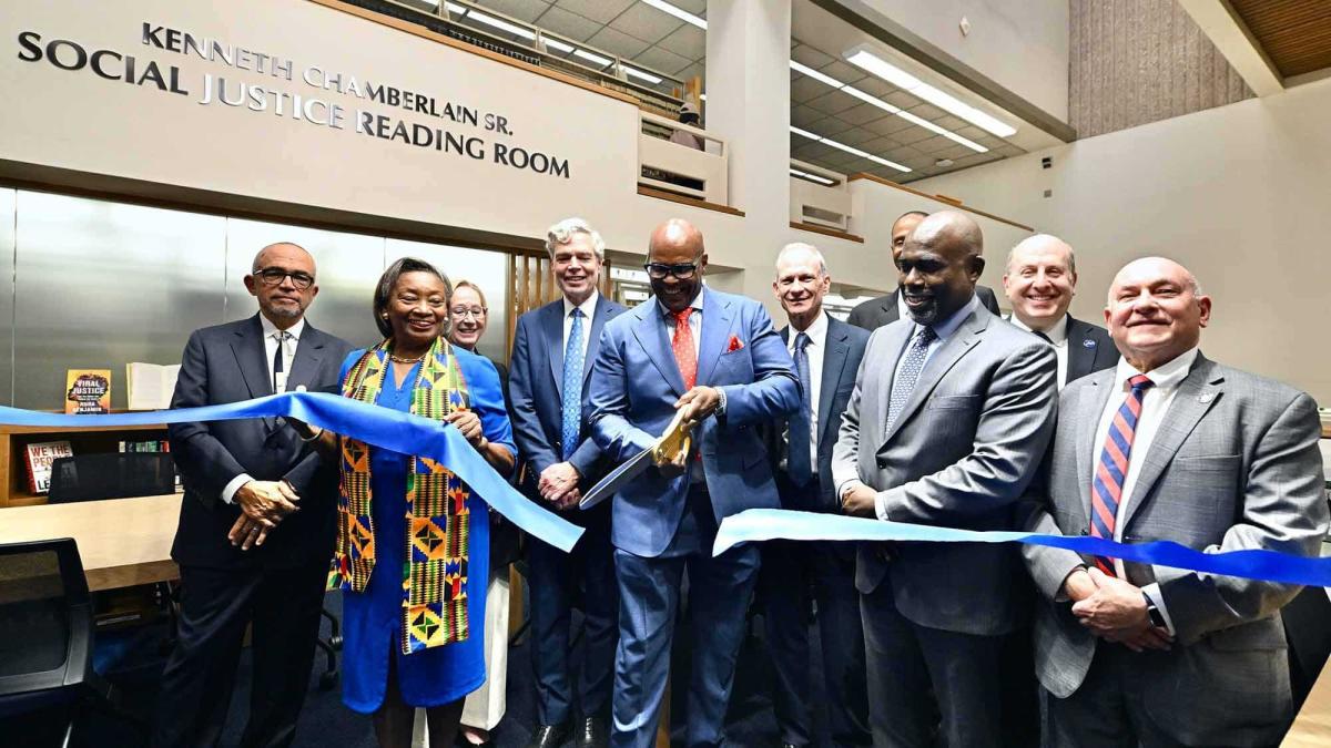 Individuals cutting a ribbon at the dedication of the Kenneth Chamberlain Reading Room at Haub Law
