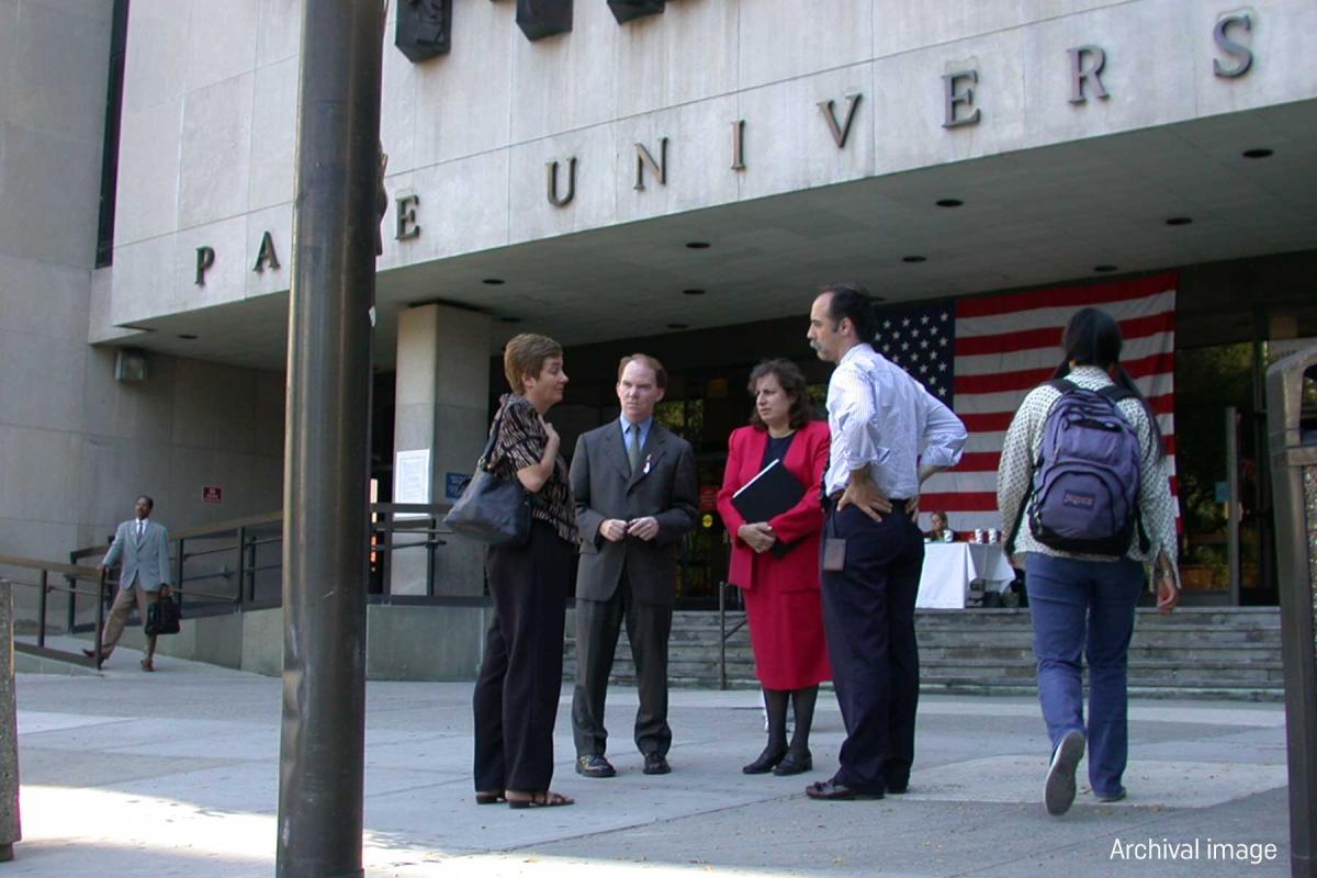 Archival image of people standing in front of One Pace Plaza with an American flag.