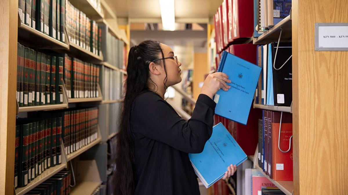 Student looking for books at the Law library.