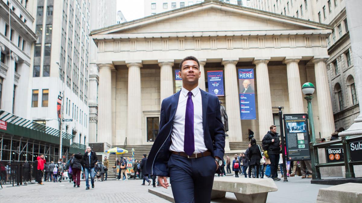 Student dressed in business attire walking in NYC.