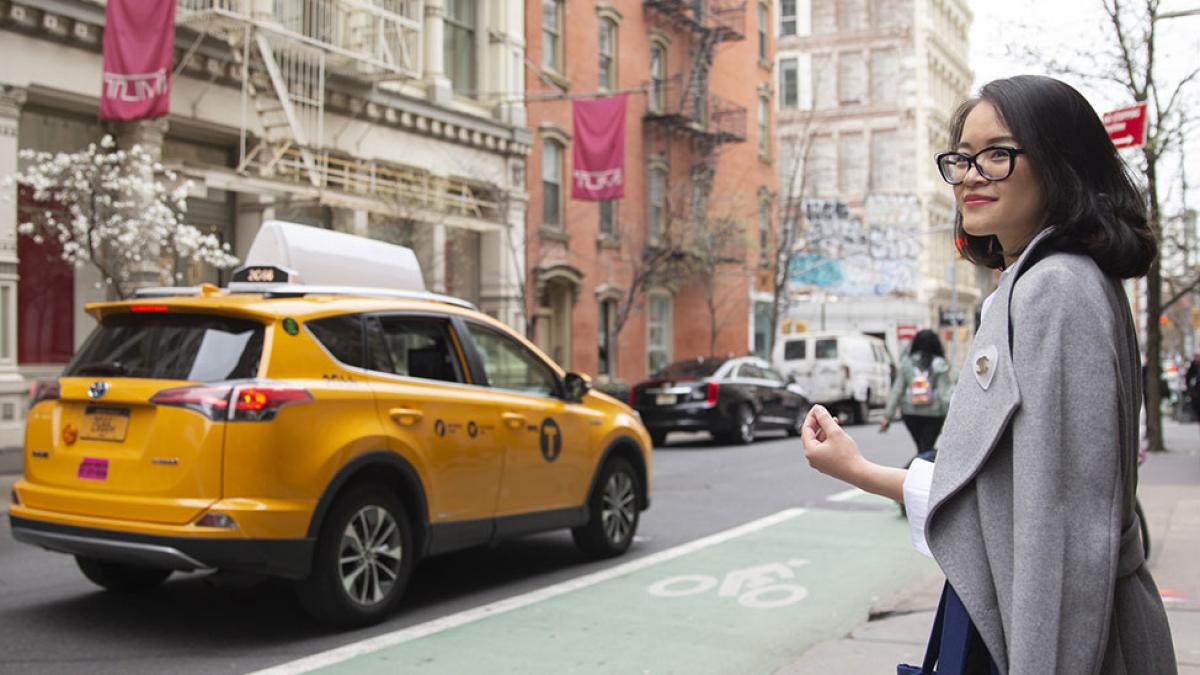 Female student in business attire walking around NYC.