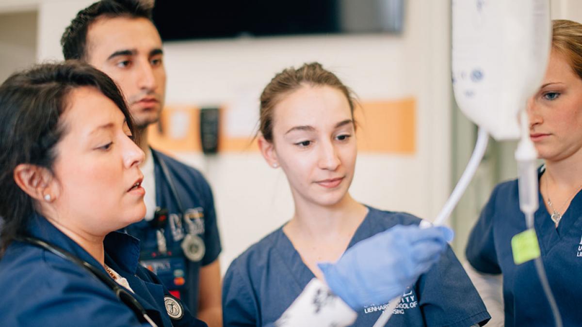 Group of Pace nursing students working on a patient.