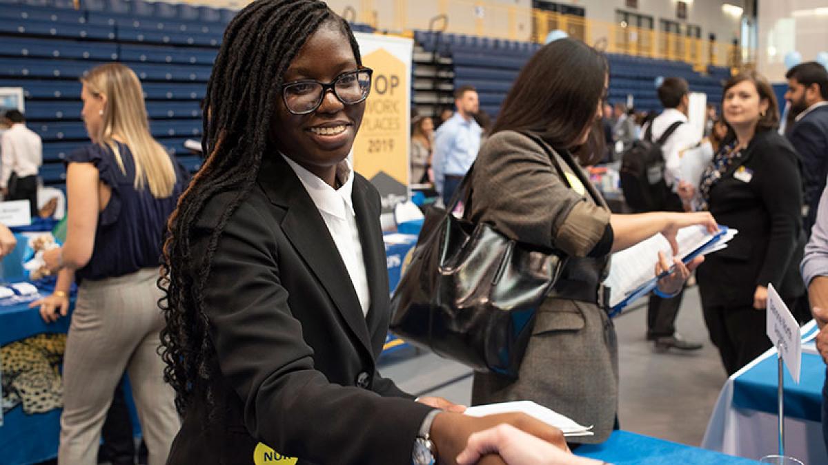 Student meeting prospective employers at a career fair held at Pace University.