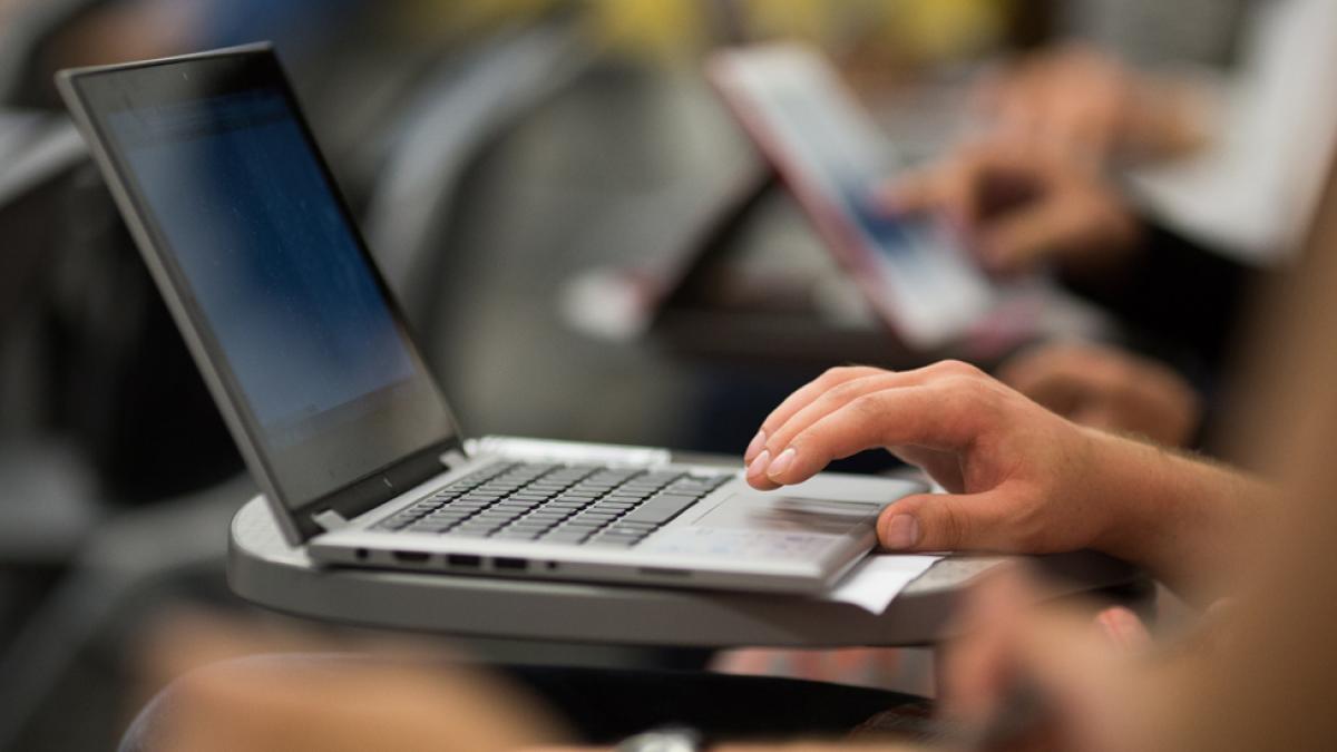 Student typing on a laptop.