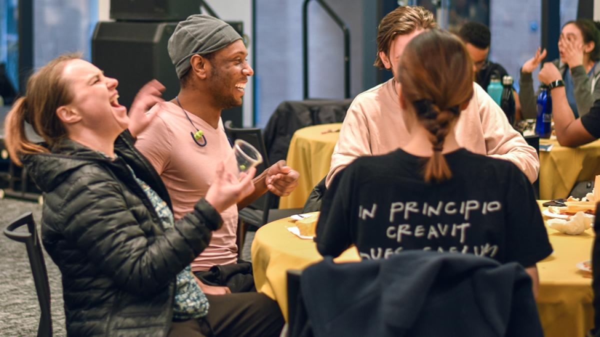 Students sitting at a table laughing.