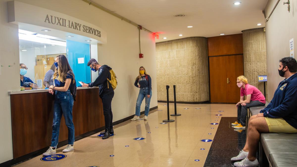 Students being helped at the Auxiliary Services window on the NYC campus.