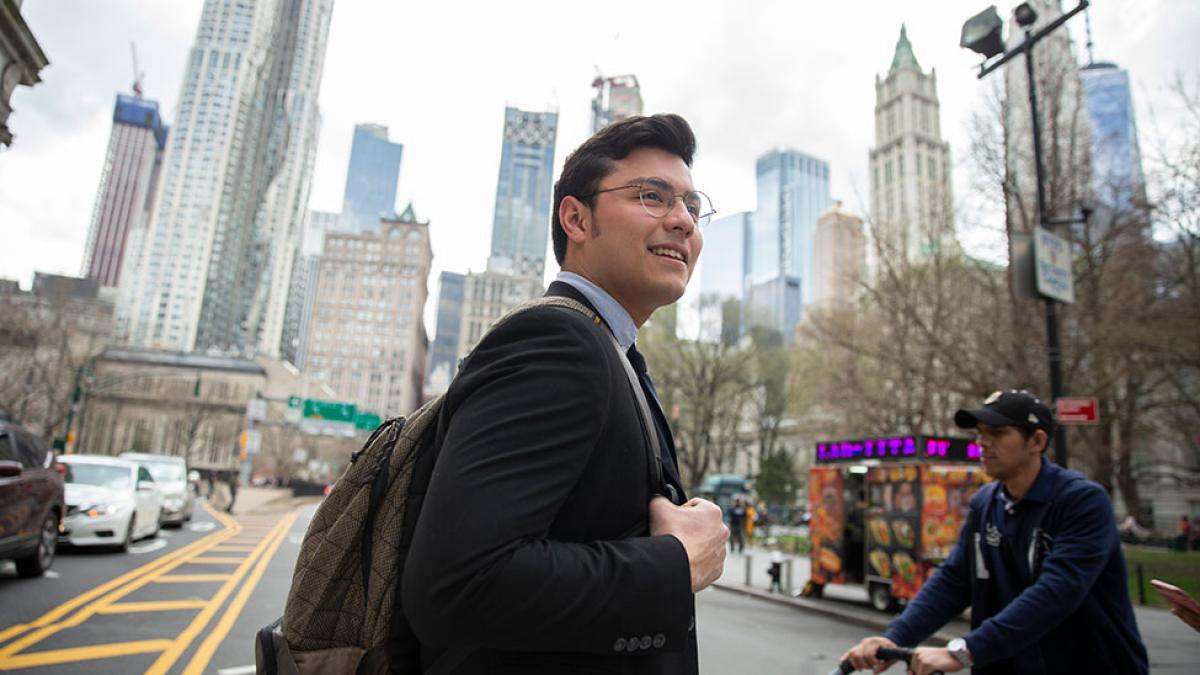 Student dressed in a suit walking around NYC.