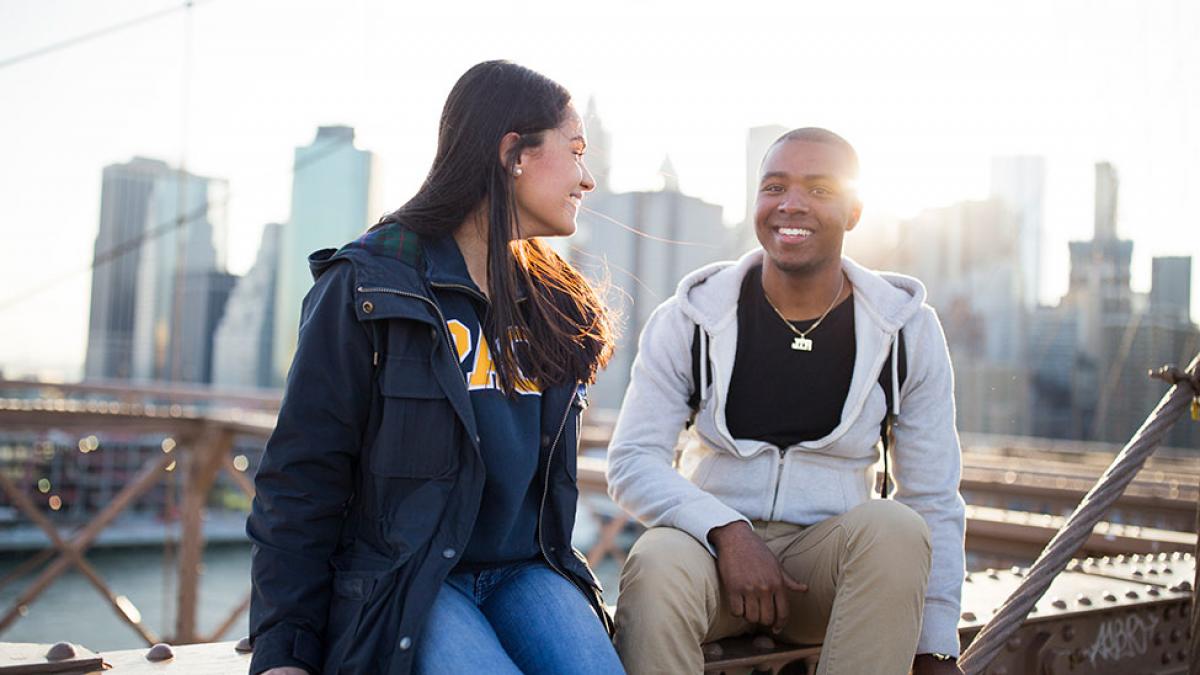 Students sitting at the Brooklyn Bridge