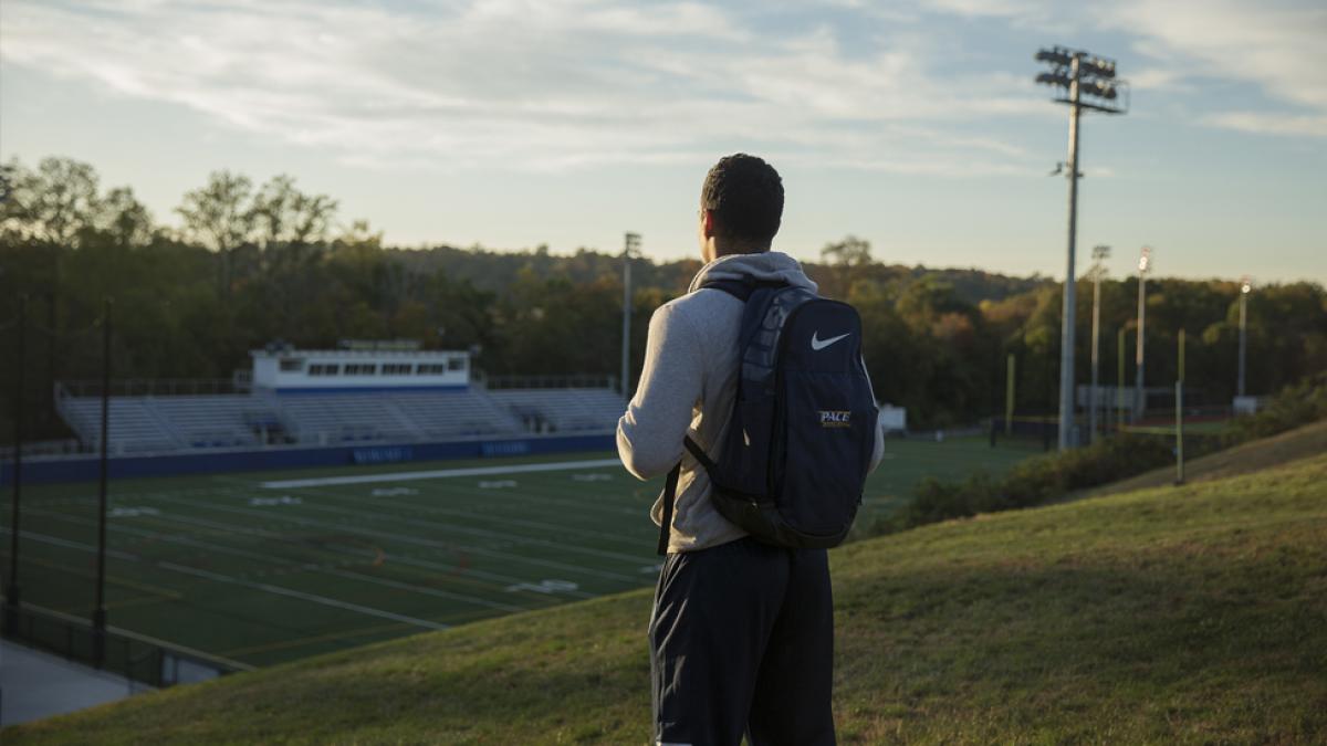 Student looking at the football field on the Westchester campus.