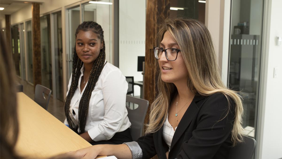 Students dressed in business attire at a meeting.