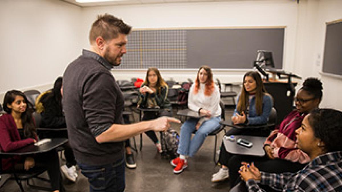 Professor speaks to students in class. 