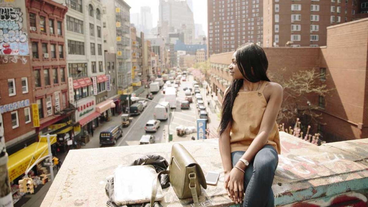 Student sitting on a bridge in NYC.