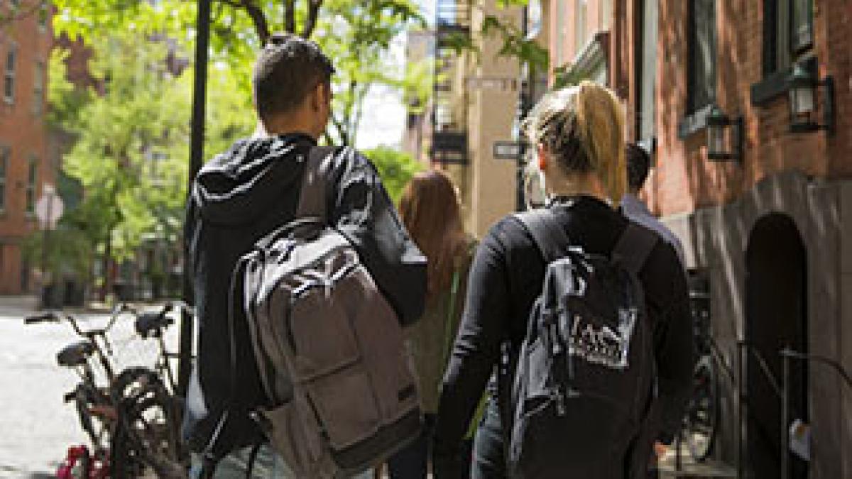 Male and female pace university students walking down a street in Manhattan