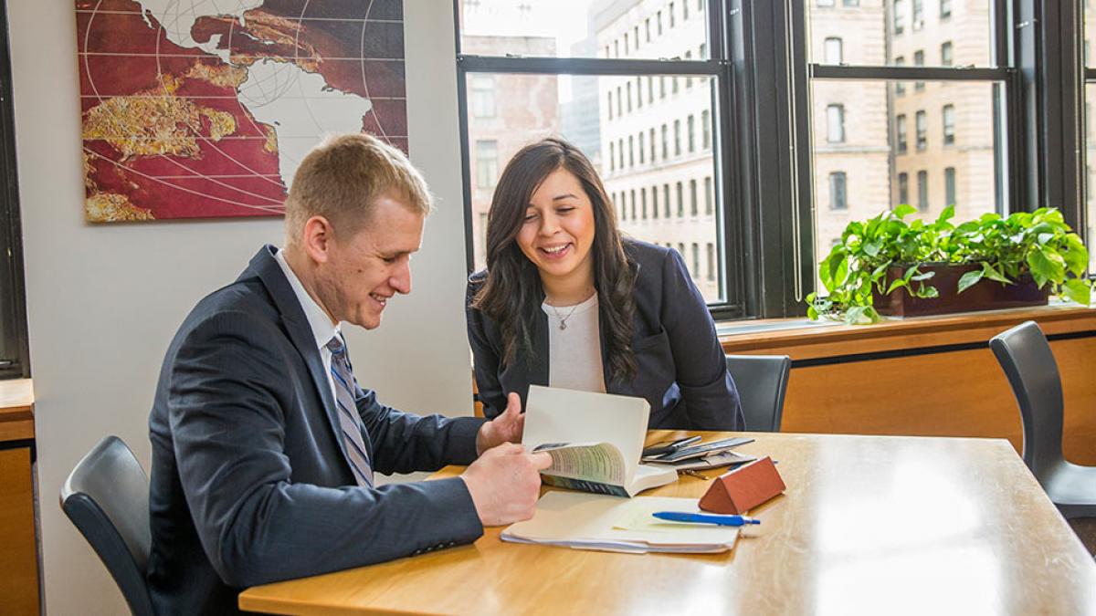 Students sitting around a desk meeting.
