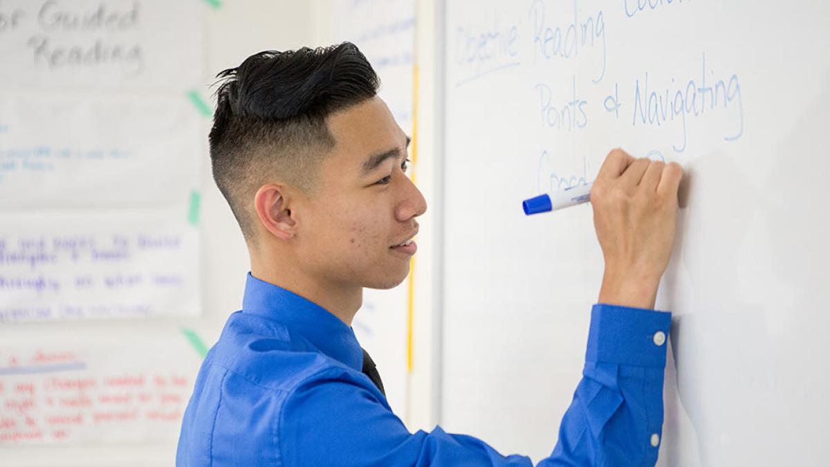 School of Education student writing on the board.