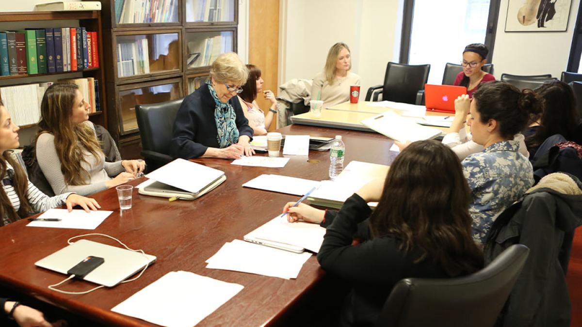 Students with professor sitting around round-table 