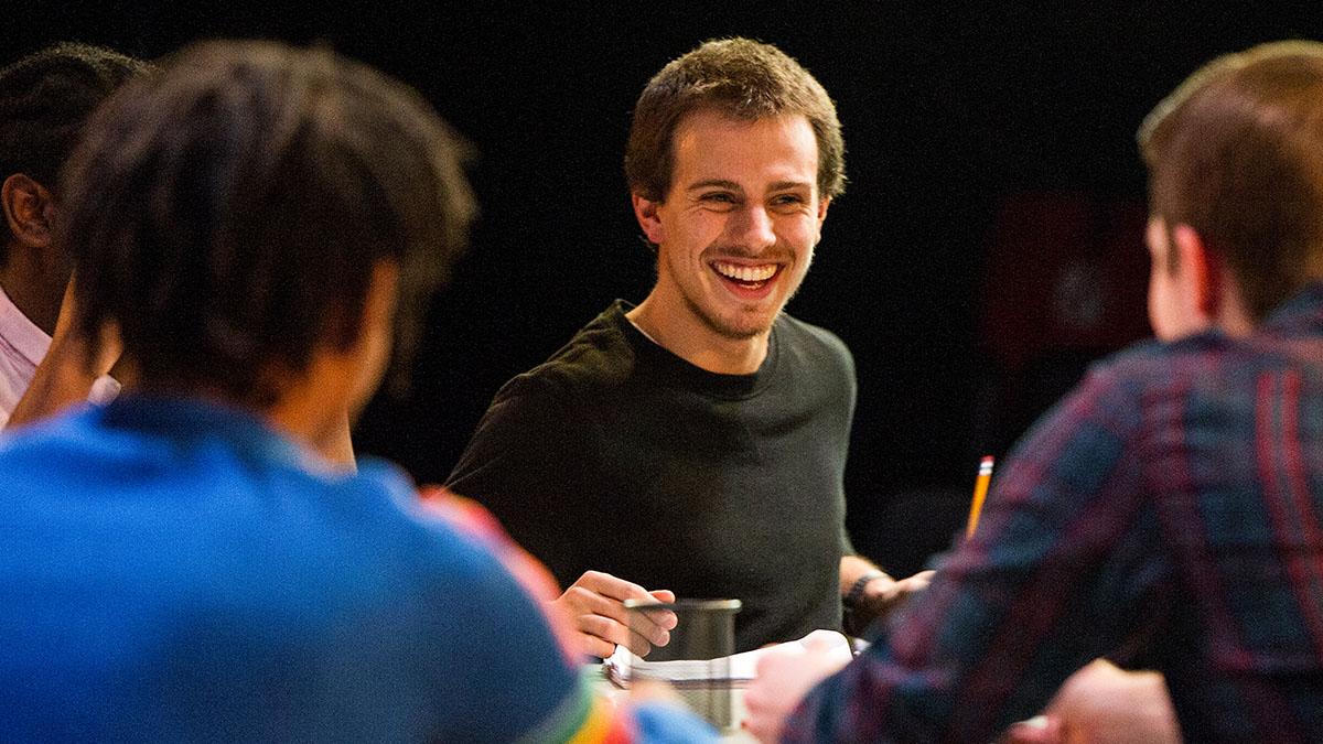 Directing student at table with other actors
