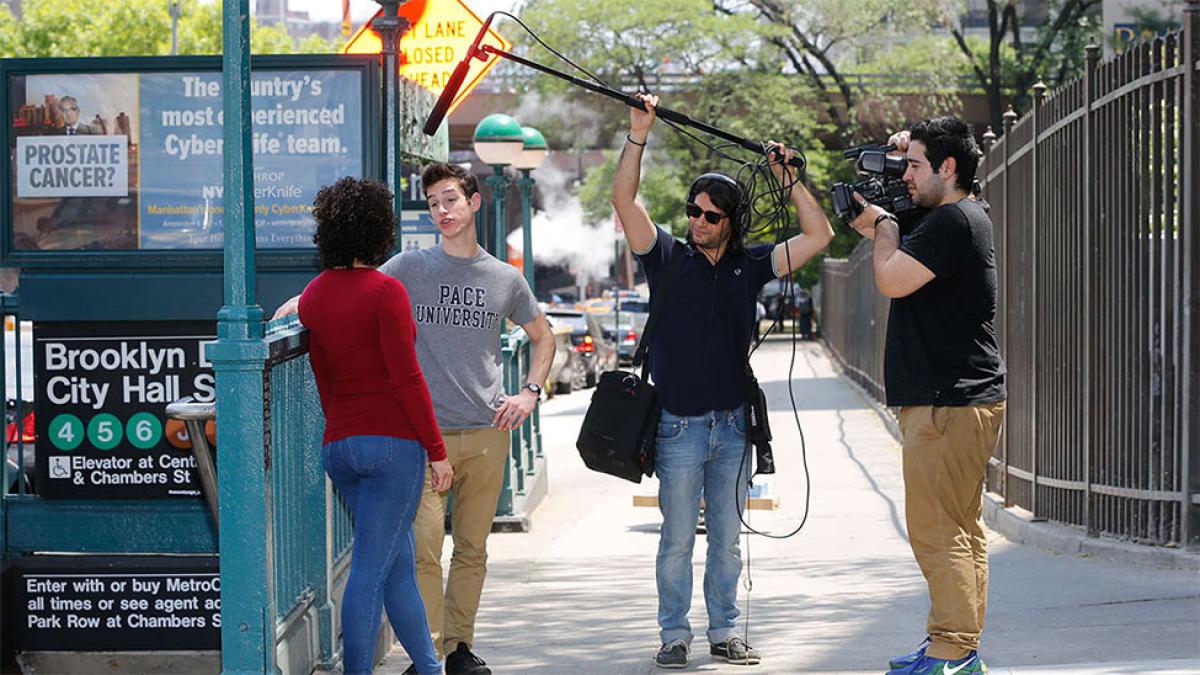 Students outside of 1 Pace Plaza with boom and shoulder camera filming students