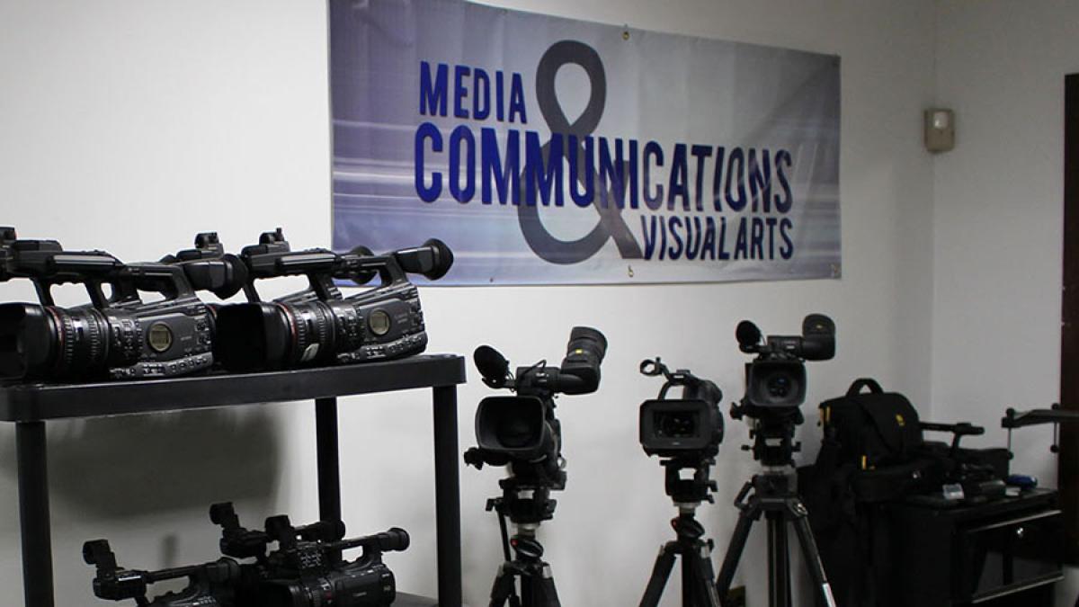 Video camera storage with Media, Communications, and Visual Arts banner on the wall
