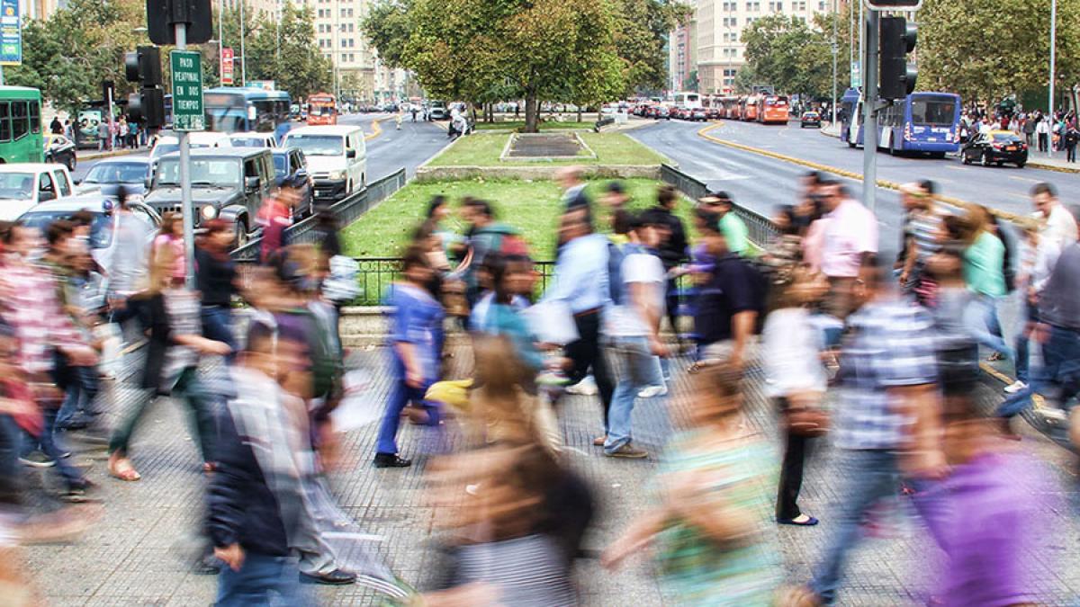 Blurry people crossing a busy intersection 