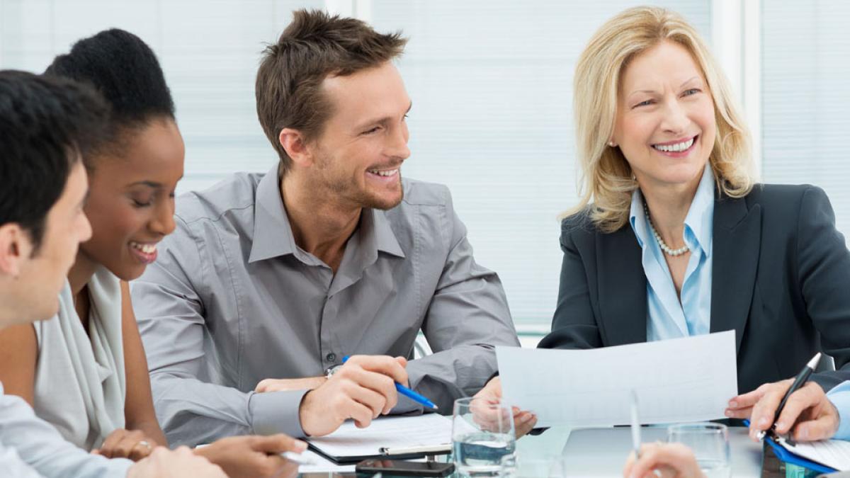 Workers in business attire sitting around a conference table representing the Center for Global Governance, Reporting, and Regulation