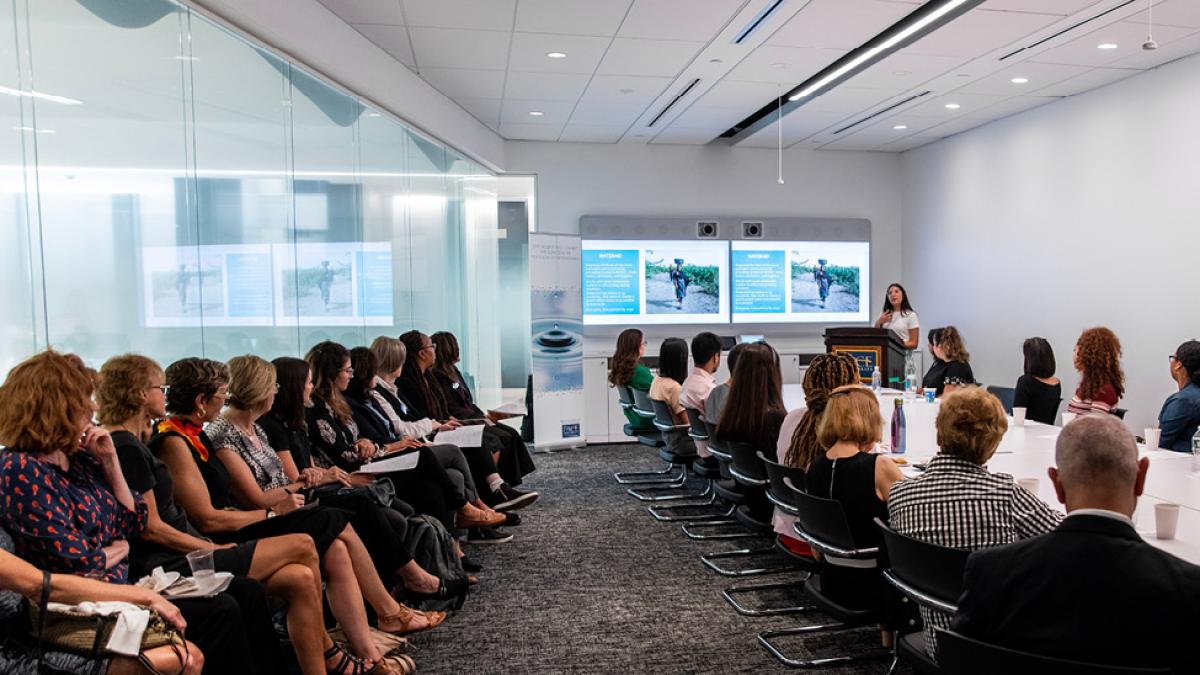 Woman speaking to a group of people in a conference room