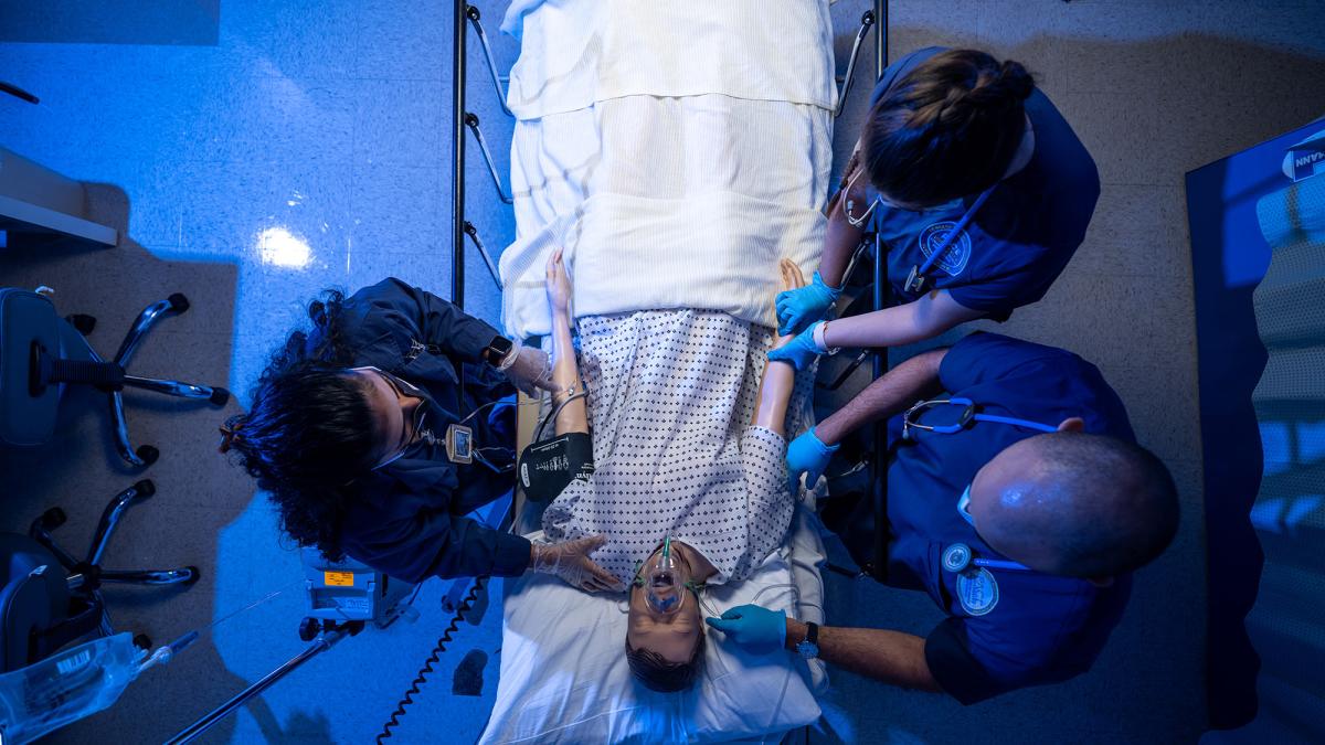 Students working on a mannequin in the simulation lab.