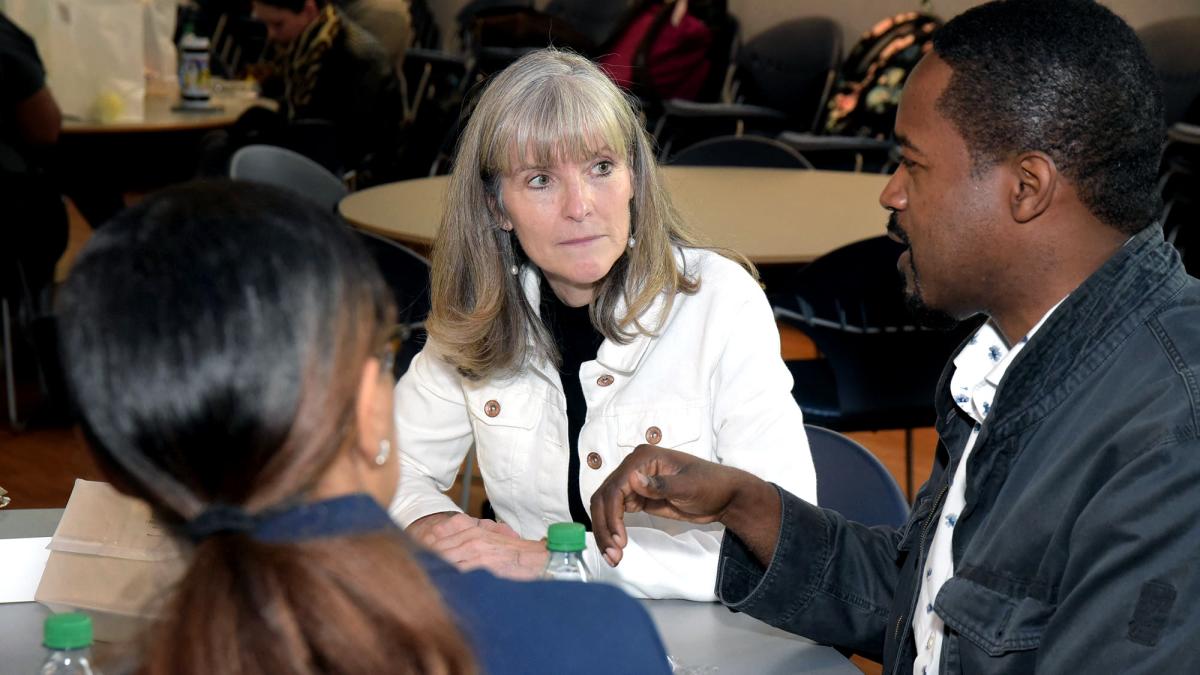 Liz Berro speaking with another student.