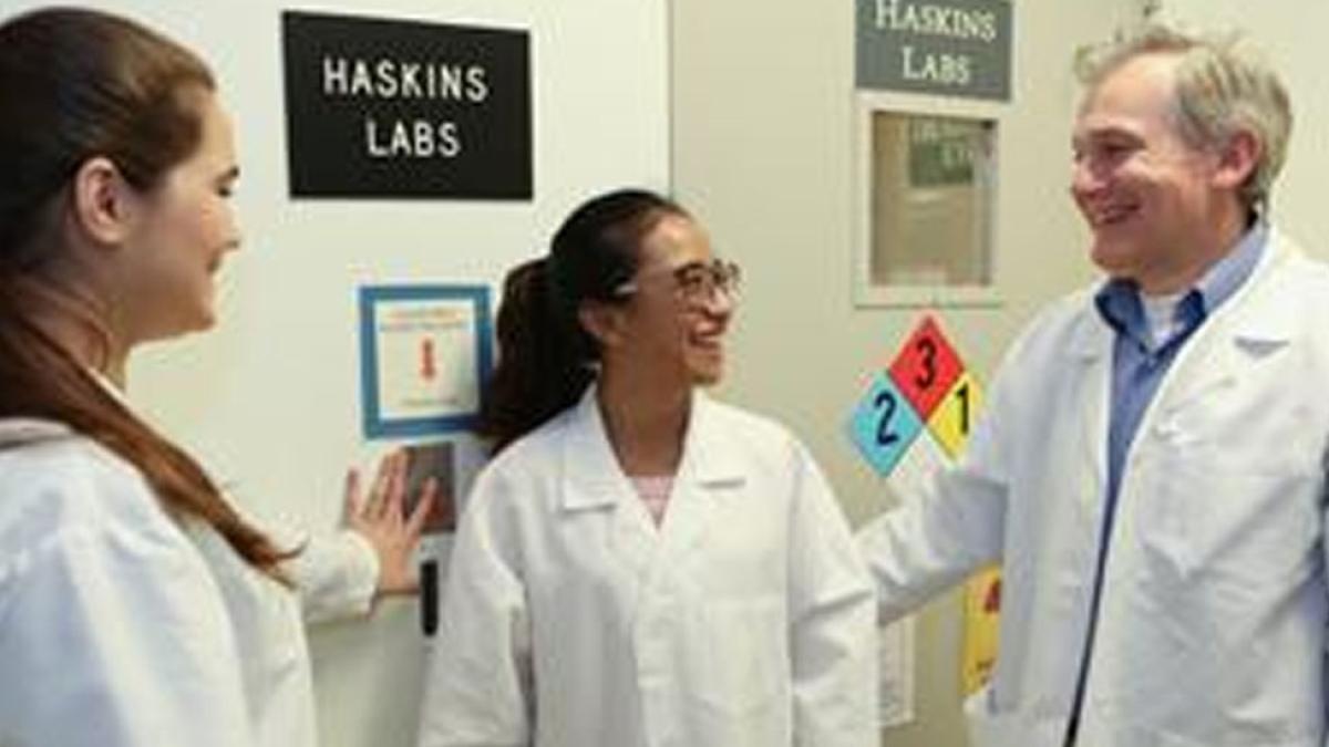 Two female students with Nigel Yarlett infront of Haskins Lab sign