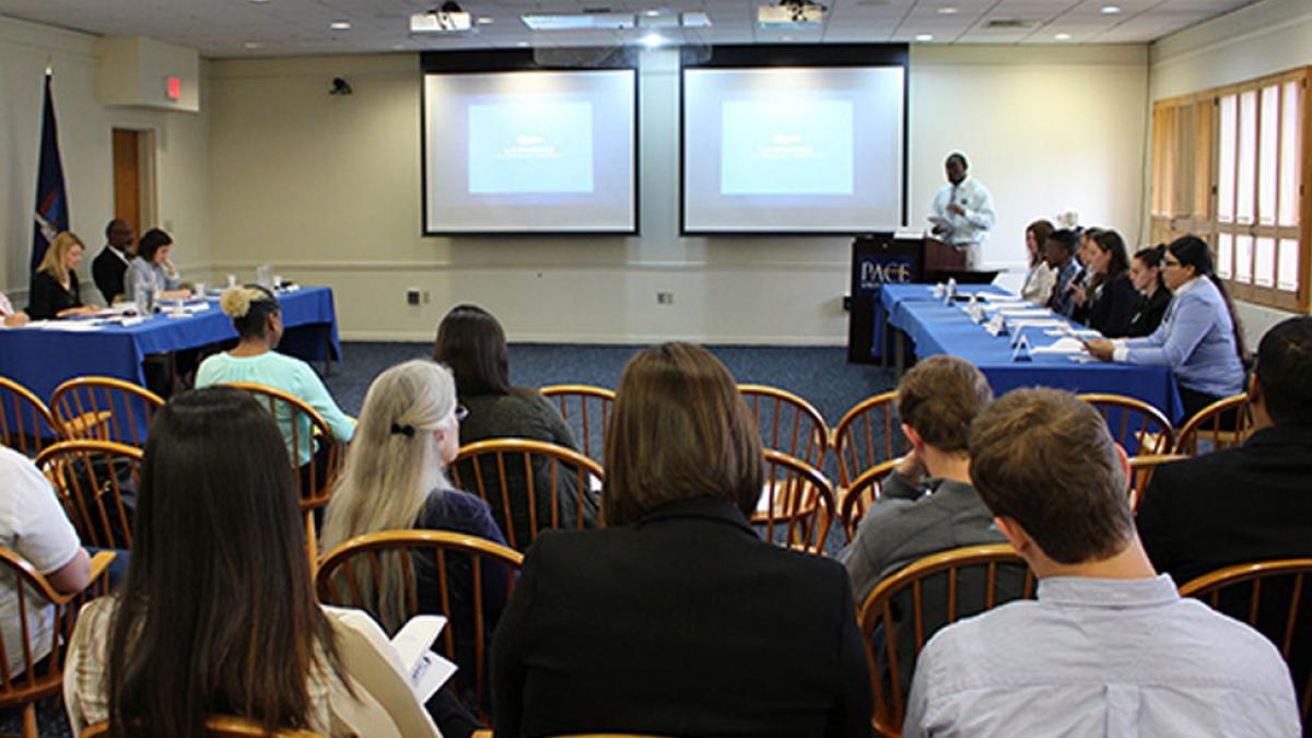 A mock court with students and faculty featuring a prosecution and defense 