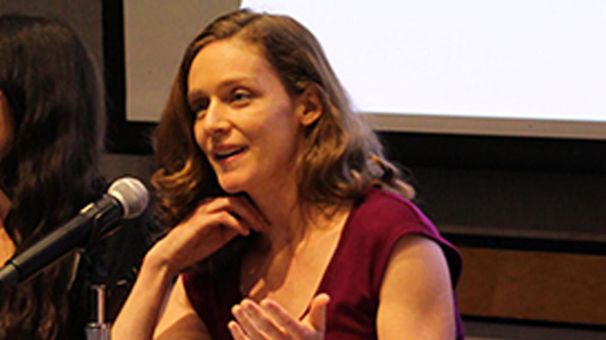 Anne Toomey behind a microphone on a panel