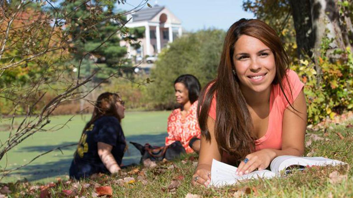 three Pace University students sitting on the lawn of the Pleasantville Campus