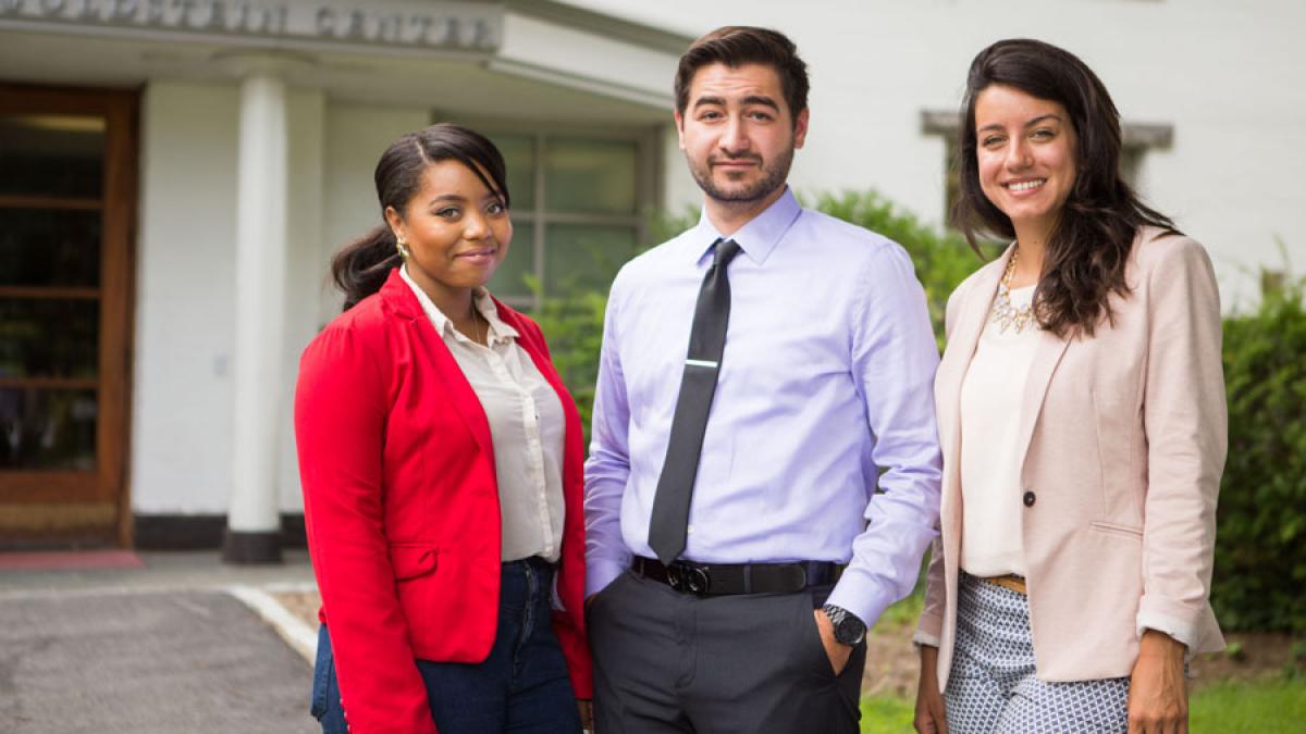 three Lubin students in business attire standing outdoors on the Pleasantville Campus of Pace University