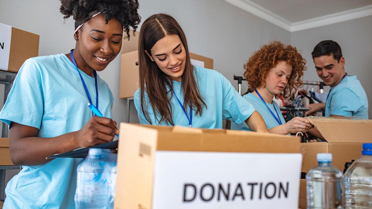 two volunteers sort through donations at a food pantry