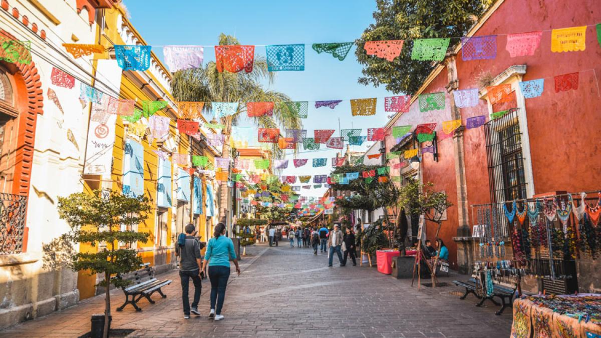 two individuals walking down a city street in Mexico