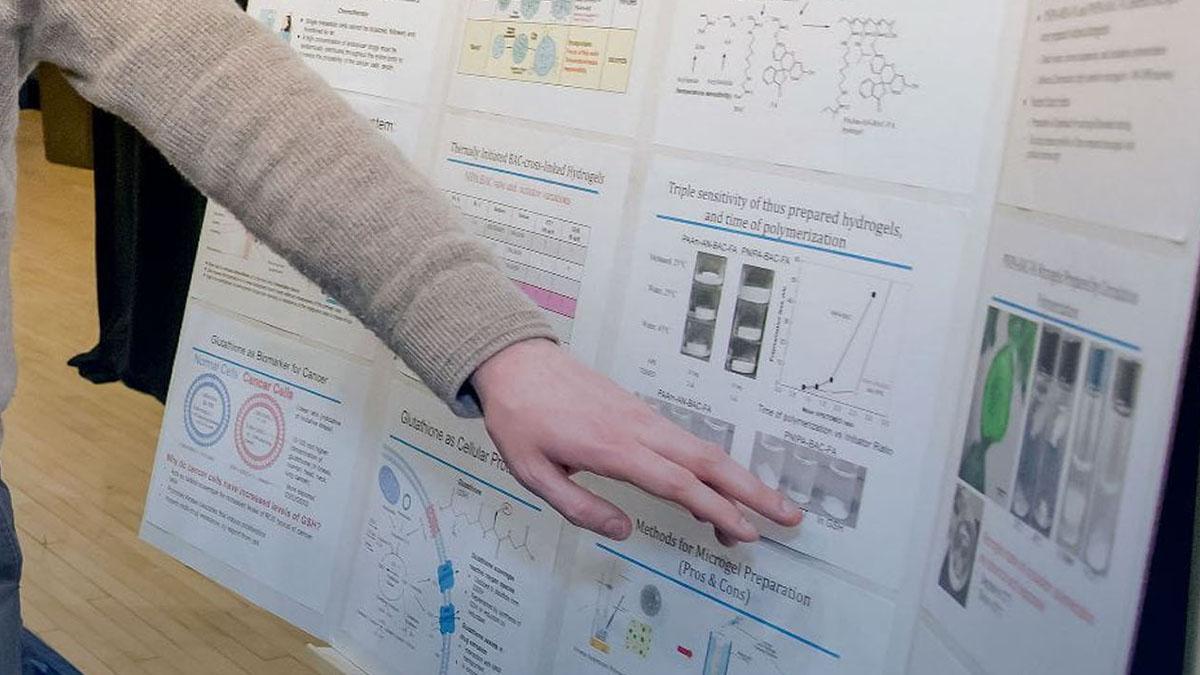 Student pointing at research board