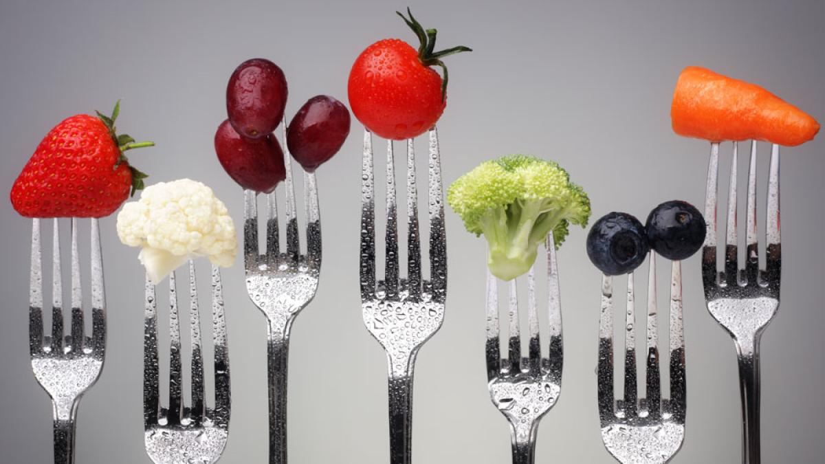 healthy foods on forks against a gray background