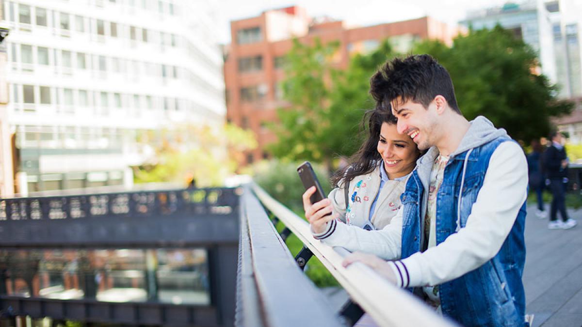 Two students looking at a cell phone.