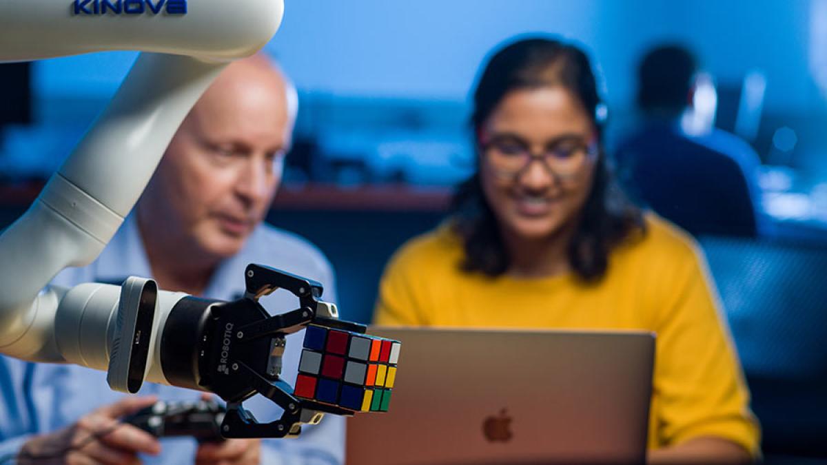 Student working with a faculty member on a robot.