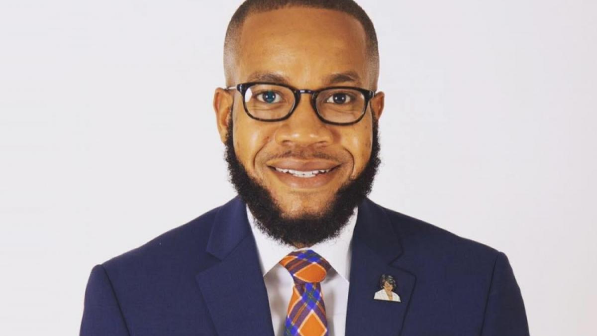 black man with a beard in a blue suit