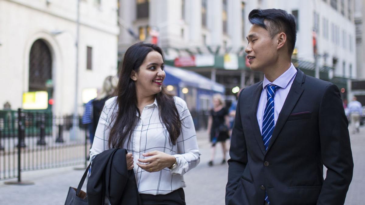 two Lubin graduate students in business attire walking in Lower Manhattan near Pace University's New York City Campus