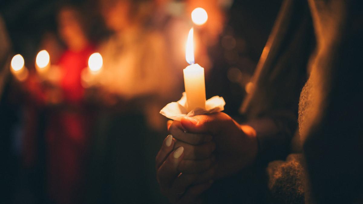 people holding vigil candles