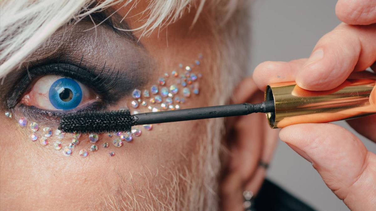 man puting on mascara