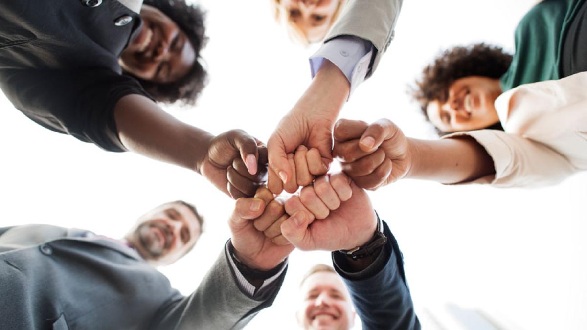 group of people fist bumping representing the idea of "application"