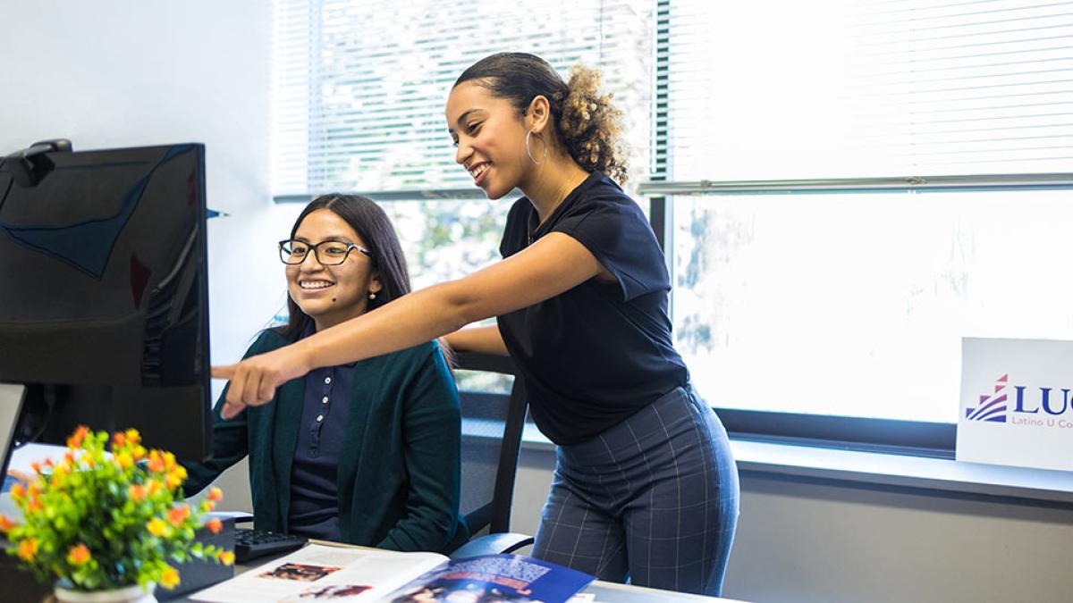 Two students looking at a computer.