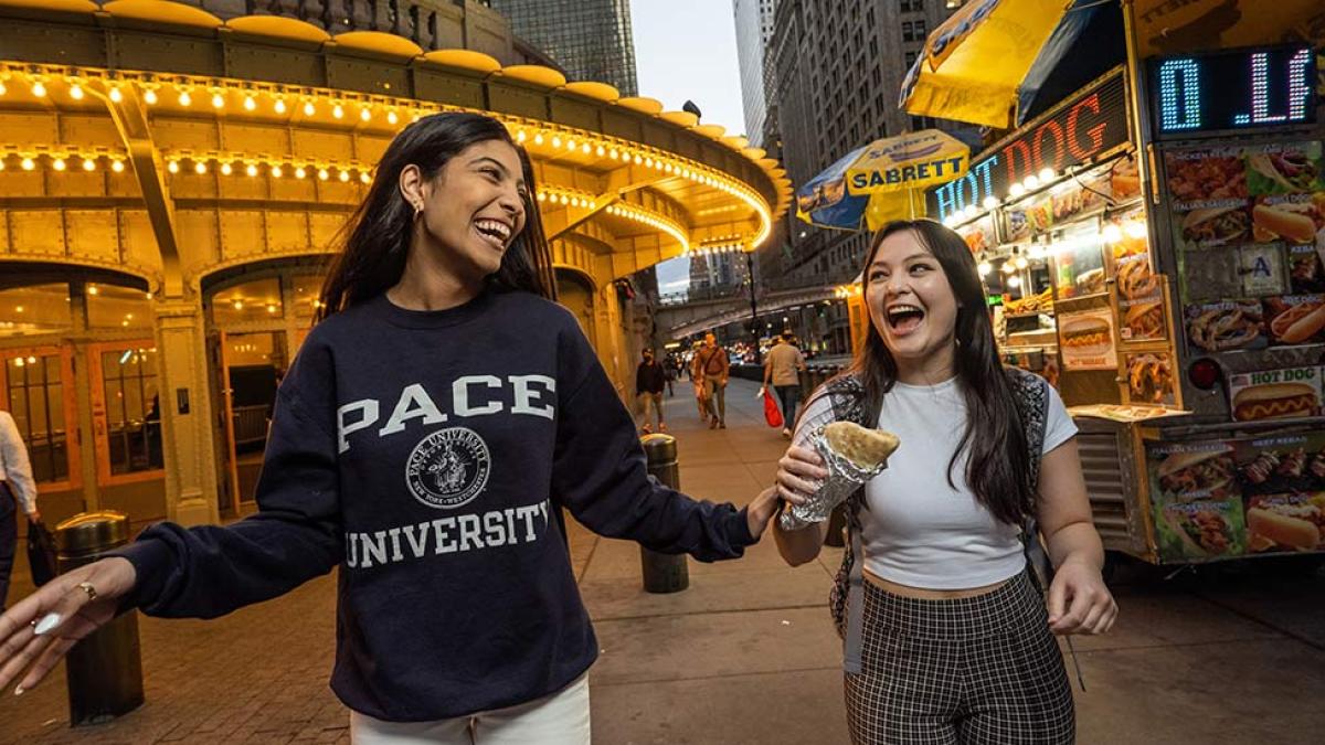 Two students talking and laughing on the street of New York City