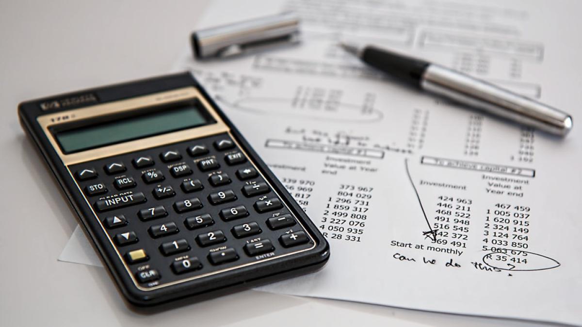 calculator, pen, and documents representing the idea of insurance