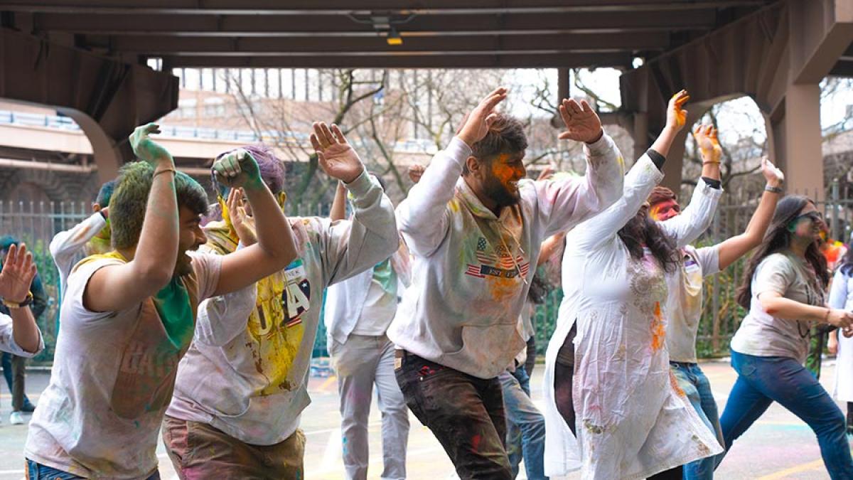 Students celebrating Holi in One Pace Plaza courtyard