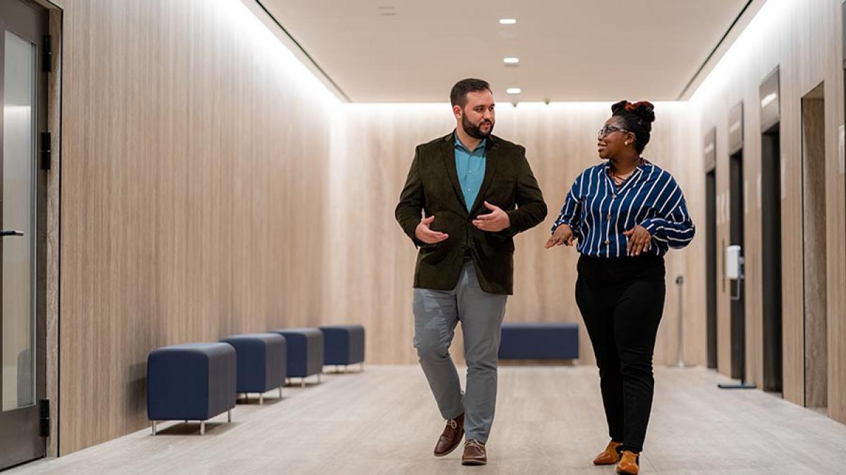 Two graduate students talking in elevator lobby